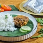 Mixiote De Pollo served in a shallow bowl on top of banana leaf.