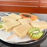 Tropical Creamy Papaya Kiwi Popsicles on a white plate.