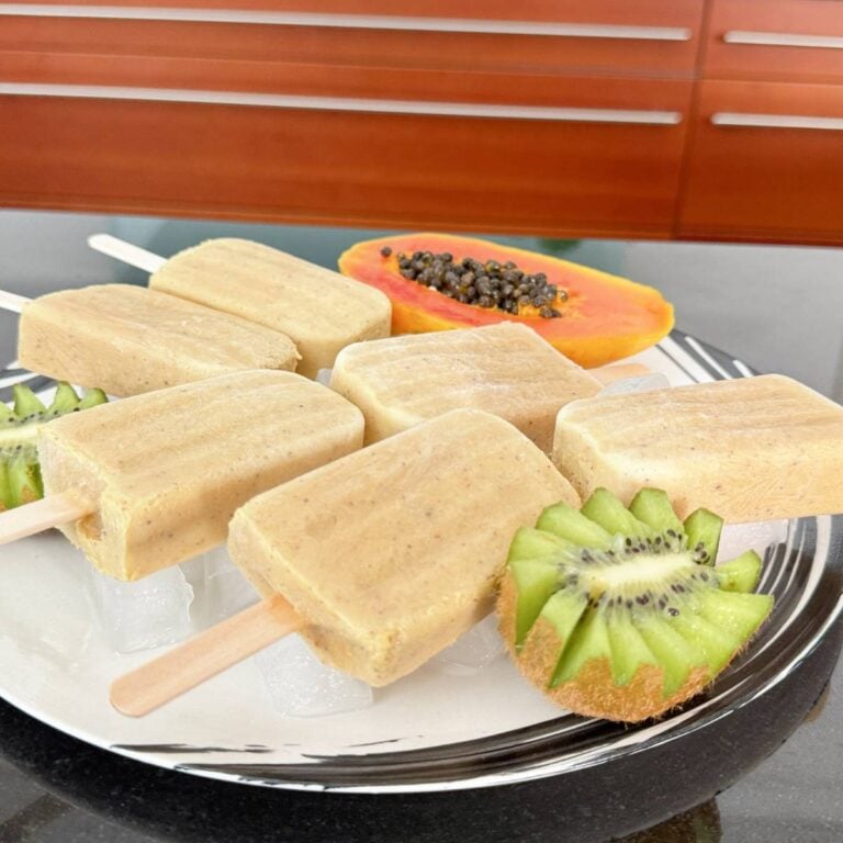 Tropical Creamy Papaya Kiwi Popsicles on a white plate.