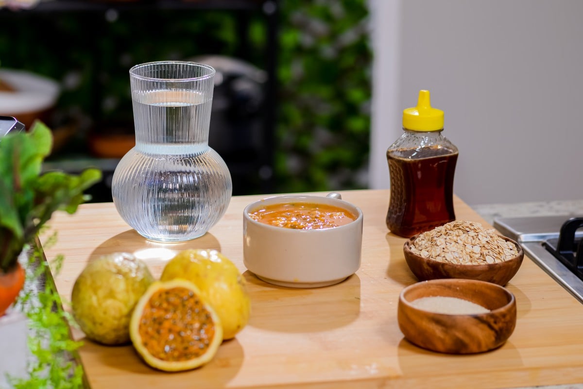 Ingredients for passion fruit juice with oats, including fresh passion fruits, passion fruit pulp, oats, honey, sugar, and water.