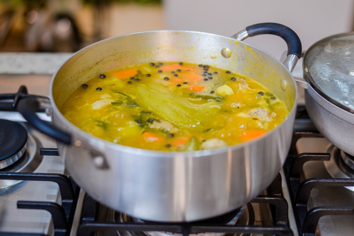 cooking dominican chicken soup in a pan