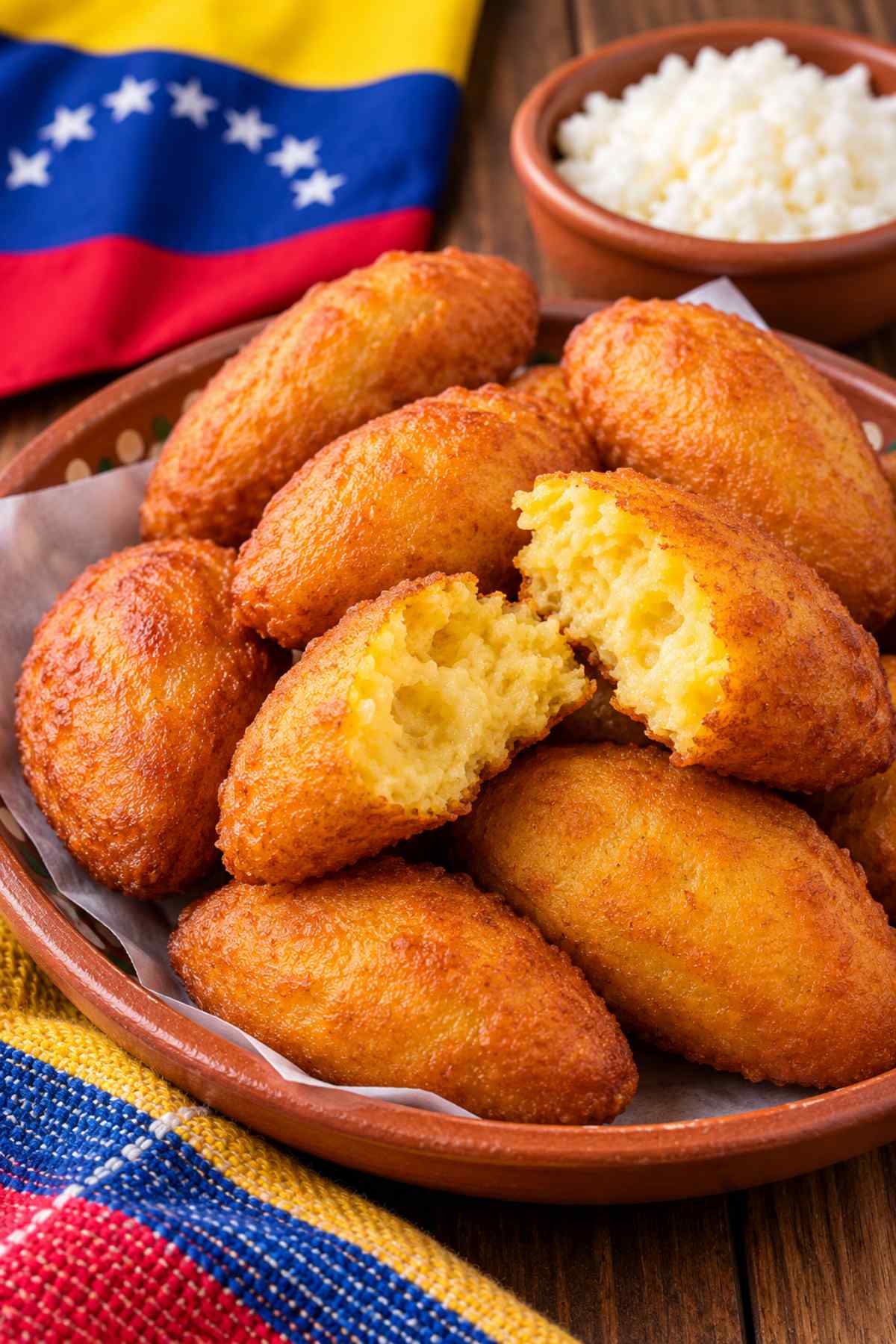 Golden Venezuelan mandocas served with white cheese and the Venezuelan flag