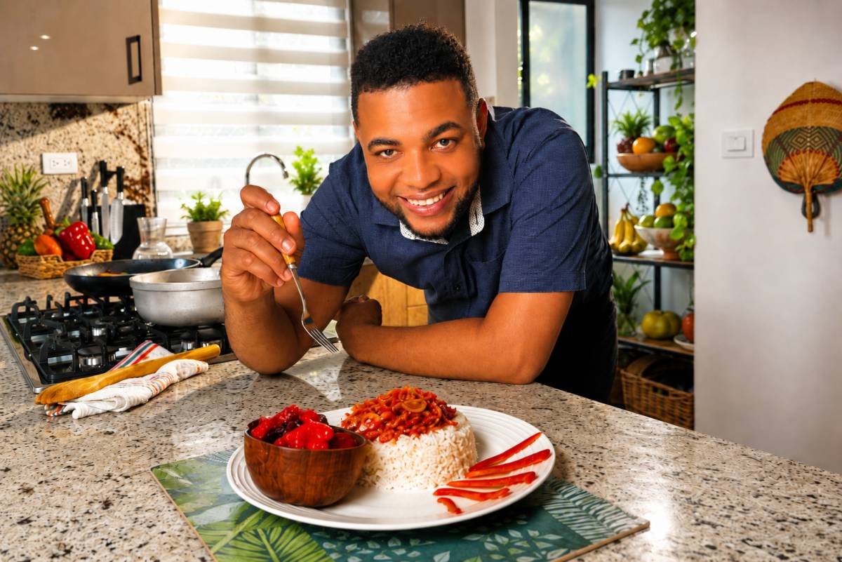 Misael serving Dominican bacalao guisado with white rice and beet salad