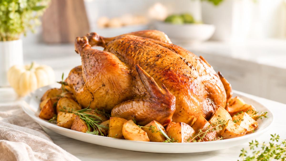 Juicy roasted turkey with crispy golden skin, potatoes, and fresh herbs